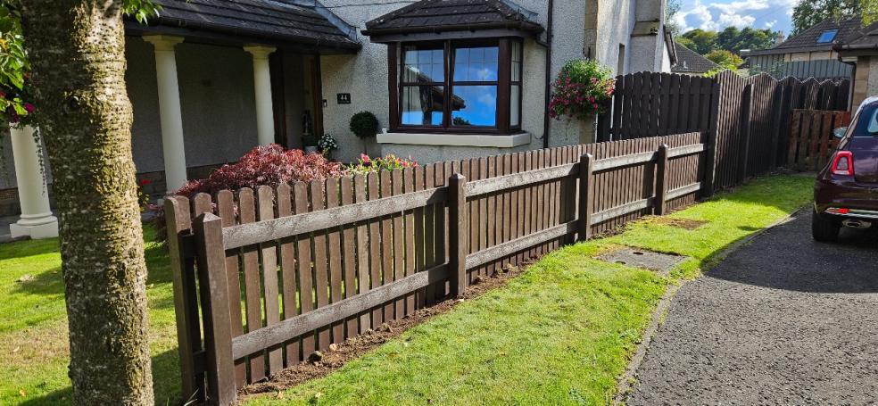 brown plastic fencing separating house front garden and driveway
