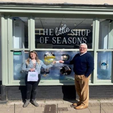 Competition winner, Hollie Broom with Roger Hemming from Roger Hemming Estate Agents, outside The Little Shop of Seasons in Honiton.