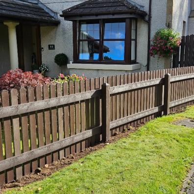 brown plastic fencing separating house front garden and driveway